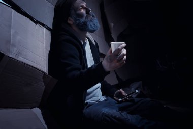 Evsiz sakallı bir adam sokakta kutulara oturup yardım istiyor. Evsiz bir insan yemek için para ister ve bir gecede.