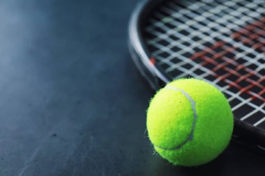 Spor ve sağlıklı yaşam tarzı. Tenis mi? Tenis için sarı top ve masada raket. Tenis konsepti olan spor geçmişi.