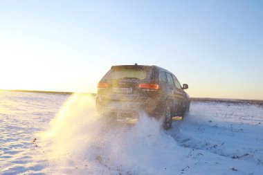 Araba, kışın tarlada. Off-road kış karları sürükleniyor. Olağanüstü spor, eğlence.