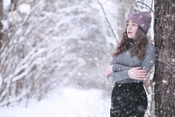 Öğleden sonra kar yağarken, parkta bir kız.