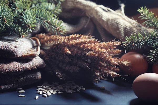 Siyah bir masada buğday ve glüten ile taze somun ekmek. Fırın ve market konsepti. Taze, sağlıklı çavdar ve beyaz somun ekmeği, çuval bezi üzerine serpiştirilmiş un. Tahıllı taze ev yapımı ekmek..