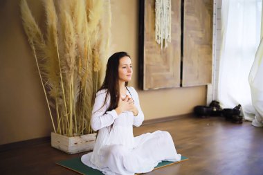 Yoga egzersizleri yapan güzel atletik kız evde meditasyonun tadını çıkarıyor. Stres yok, sağlıklı alışkanlık yok, endişe giderme konsepti yok. Lotus.
