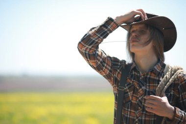 Sonbaharda tarlada şapkalı bir kovboy.