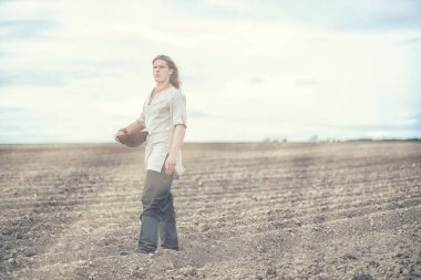 İskandinav görünüşlü genç bir köylü grai ile alan ekiyor