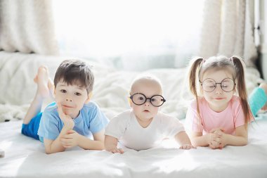 Çocuklar yeni doğan bebeğin yanında yatar, küçük kardeşim. Çocukların duyguları..