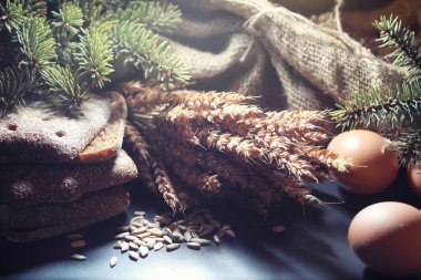 Siyah bir masada buğday ve glüten ile taze somun ekmek. Fırın ve market konsepti. Taze, sağlıklı çavdar ve beyaz somun ekmeği, çuval bezi üzerine serpiştirilmiş un. Tahıllı taze ev yapımı ekmek..