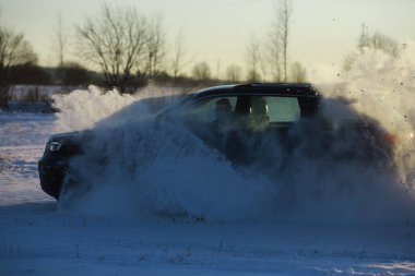 Araba, kışın tarlada. Off-road kış karları sürükleniyor. Olağanüstü spor, eğlence.