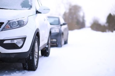 Modern SUV arabası kış yolunun kenarında duruyor. Kayak merkezine aile gezisi. Kış ya da bahar tatili macerası. Araba kışın karlı yolda dağlarda