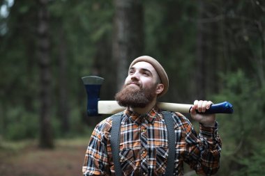 Büyük baltalı sakallı bir oduncu ağacı inceliyor.  