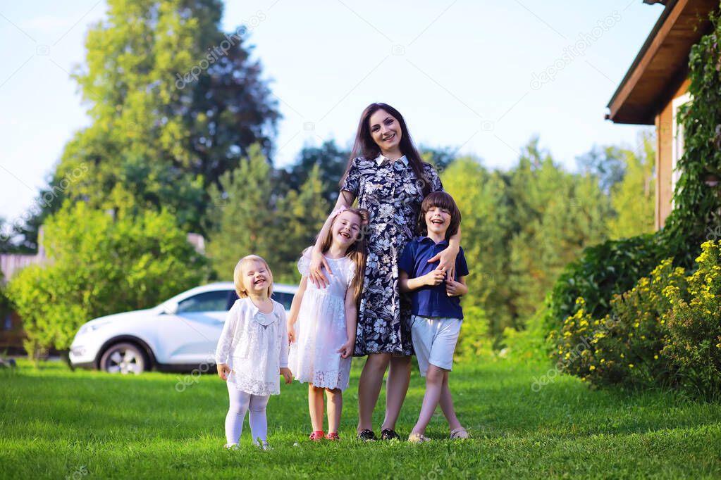 Young large family on a summer morning walk. Beautiful mother with children playing in the park.
