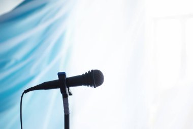 Mikrofonun yanında dur. Adam tripodun üzerinde bir mikrofon tutuyor. Sanatçının bir mikrofonla performansı. Mikrofonlu bir sahne.