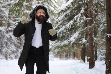 Palto ve İskoç kumaşlı yakışıklı bir adamın açık hava portresi. Sıradan kış modası.
