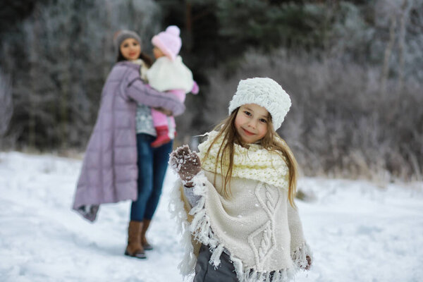 Happy family playing and laughing in winter outdoors in snow. City park winter day