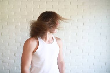 Uzun saçlı genç adam başını sallıyor.