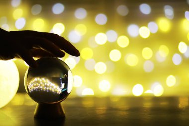Yerde Bokeh 'le kristal küre var. Renkli ışık saçan cam top, yeni yıl kutlaması konsepti..