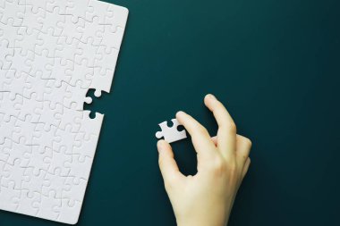 Entelektüel bulmacalar. Bulmaca boş. El yapboz parçalarını bir araya getirir. Beyin eğitimi.