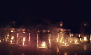 Camda mumlar olan bir arka plan. Mumlar karanlık bir yerde yanar. Huzur içinde yat..