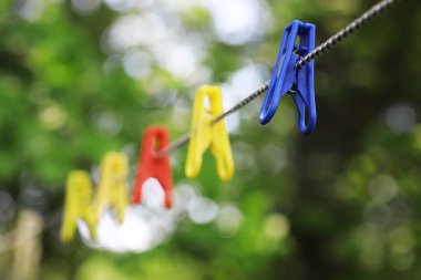 Yazın çamaşır ipinde mandallar. Kuru giysiler dışarıda. İpte giysiler.