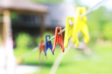 Yazın çamaşır ipinde mandallar. Kuru giysiler dışarıda. İpte giysiler.