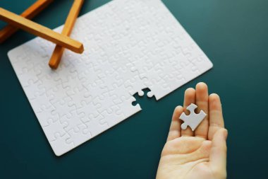 Entelektüel bulmacalar. Bulmaca boş. El yapboz parçalarını bir araya getirir. Beyin eğitimi.