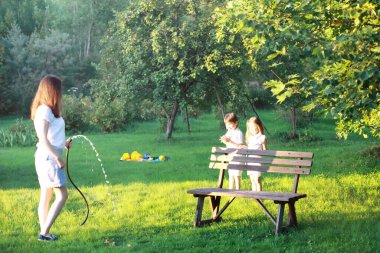 Yazın yürüyüşe çıkan çocuklar. Çocuklar kırsalda şımarır. Kahkaha ve su sıçratma.