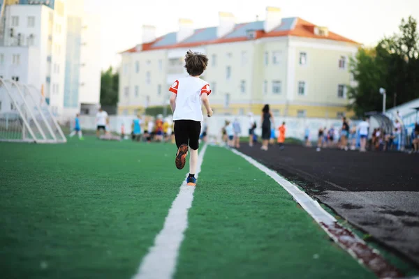 那孩子在体育场参加体育活动 男孩踢足球前的训练 — 图库照片