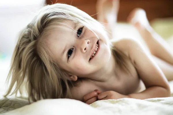 金发小女孩躺在床上 情绪激动的幼儿姿势 — 图库照片
