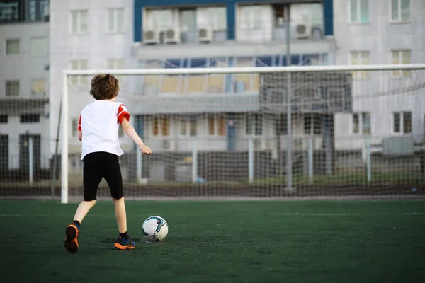 那孩子在体育场参加体育活动 男孩踢足球前的训练 — 图库照片