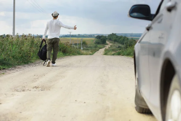 Mężczyzna Idzie Wiejską Drogą Autostopowicz Kraju Mężczyzna Zatrzymuje Przejeżdżający Samochód — Zdjęcie stockowe