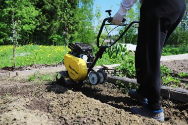 Çiftçi bir bahçe kazıyor. Elinde hasatçı olan bir adam bahçeyi sürüyor. Gri saçlı dede bahçeyi biçiyor..