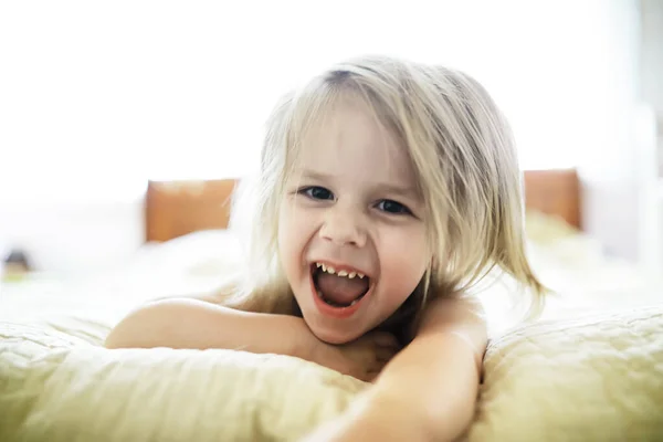 Küçük Sarışın Kız Yatağa Uzanıyor Duygusal Çocuk Pozu — Stok fotoğraf