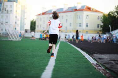 Çocuk spor için stadyuma gider. Futbol oynamadan önce antrenman yapan çocuk..