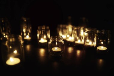 Camda mumlar olan bir arka plan. Mumlar karanlık bir yerde yanar. Huzur içinde yat..