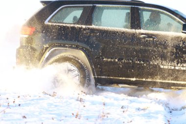 Araba, kışın tarlada. Off-road kış karları sürükleniyor. Olağanüstü spor, eğlence.