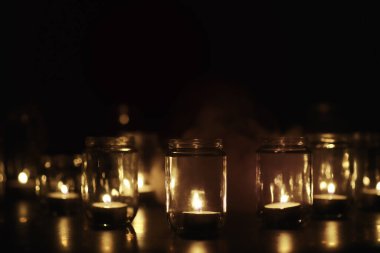 Camda mumlar olan bir arka plan. Mumlar karanlık bir yerde yanar. Huzur içinde yat..