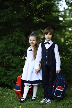 Okul üniformalı çocuklar sokakta yürürler. Çocuklar yıl sonunda sevinir ve eğlenirler. Tatiller.