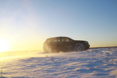 Araba, kışın tarlada. Off-road kış karları sürükleniyor. Olağanüstü spor, eğlence.