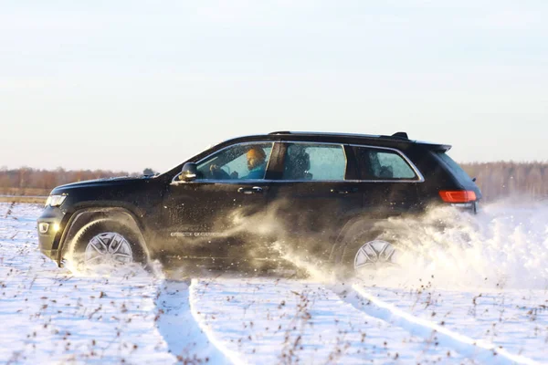 Araba, kışın tarlada. Off-road kış karları sürükleniyor. Olağanüstü spor, eğlence.