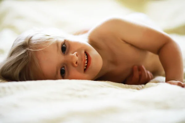 Ένα Μικρό Παιδί Ξανθά Μαλλιά Ξαπλώνει Στο Κρεβάτι Κοριτσάκι Παίζει — Φωτογραφία Αρχείου