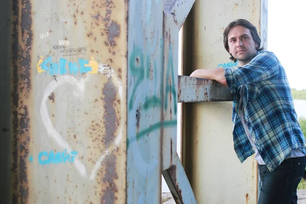 Bir adam sakallı ve kot pantolon endüstriyel bölgede standları