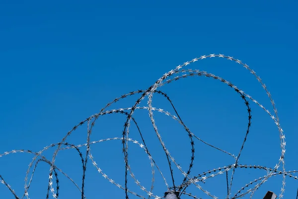 Barbed wire on fence with blue sky — Stock Photo, Image