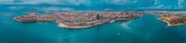 Hava aracı panoraması ya da Valetta 'nın şehir manzarası, güneşli bir günde Malta' nın başkenti ve arka planda fırtına bulutları var..