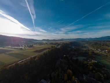 Slovenya 'nın Trzic bölgesinin sabah hava aracı panoraması. Görünür sabah sisi, katmanlı puslu sis ve güneş doğmak üzere..