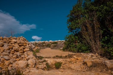 Malta 'nın doğusunda Xemxija miras patikası. Sıcak bir yaz gününde, mavi gökyüzüyle vadinin yukarısındaki kayalık yol manzarası.