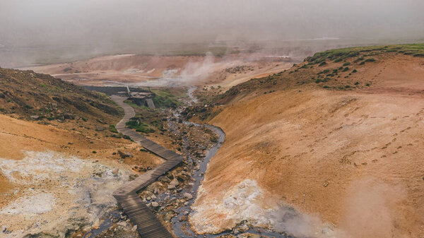 Drone view of empty geothermal Krysuvik area on Reykjanes peninsula in Iceland on early summer morning. Visible sulphur rising from the ground.
