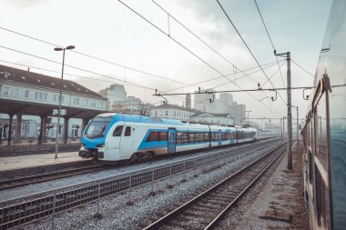 Slovenya 'nın Kocevje kentindeki banliyö hizmetine başlamak üzere, bir kış akşamı Ljubljana istasyonunda modern elektrikli tren bekliyor..