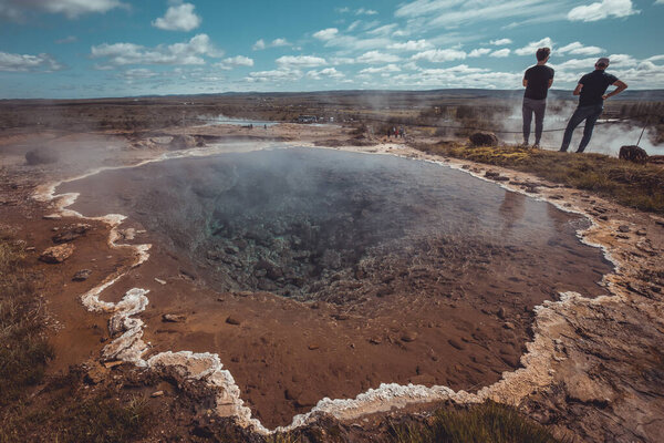 One small pond of volcanic water at Strokkur geyser area on Iceland on a beautiful sunny day. Sulphur residue visible on the shore of the lake.