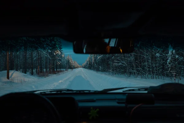 夕方の凍結温度では 道路上の緑 危険な雪や氷の中の森を介して孤独な直線道路 背景に太陽と美しい青の設定 — ストック写真
