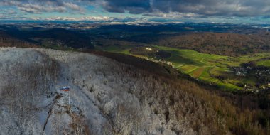 Slovenya 'nın Grosuplje kenti yakınlarında Ostri Vrh' den güzel Radensko polyesine doğru geniş bir manzara var. Üstte kar, altta yeşil çayırlar..