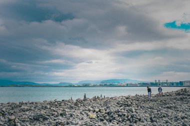 Reykjavik, İzlanda 'daki rıhtımların önündeki taş bankası. Soğuk bir yaz günü bulutlarla dolu. Gezgin taşlar ya da kazıklar görülür..